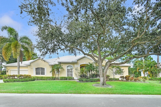 single story home with a garage and a front lawn