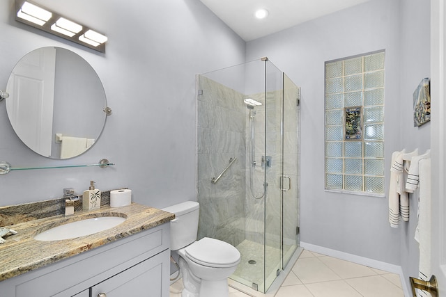 full bathroom with vanity, baseboards, tile patterned flooring, a shower stall, and toilet