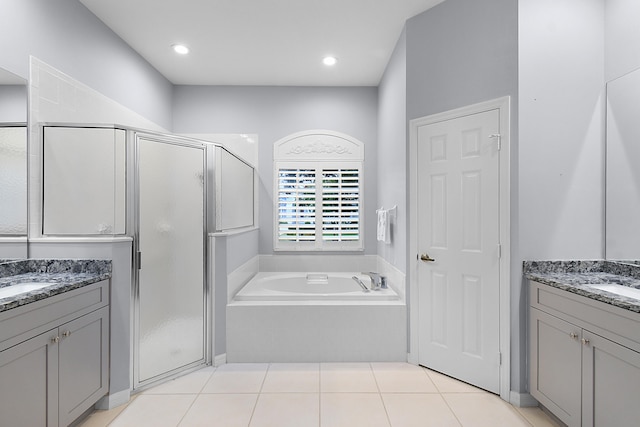 full bathroom with two vanities, a stall shower, a sink, tile patterned flooring, and a bath