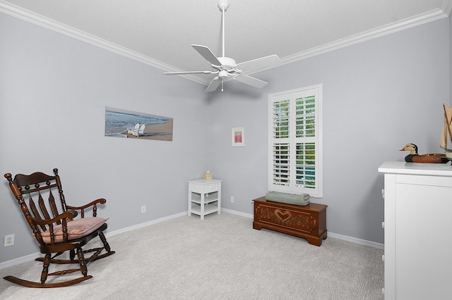 sitting room with baseboards, a ceiling fan, carpet, and ornamental molding