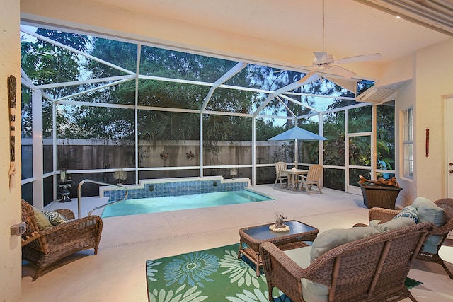 view of pool with glass enclosure, a fenced in pool, a ceiling fan, and a patio area