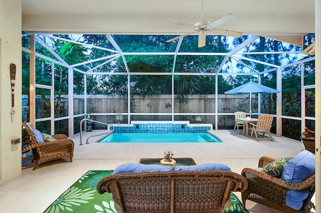 view of pool with a patio area, glass enclosure, ceiling fan, and a fenced in pool