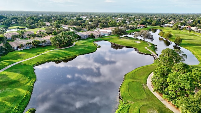 drone / aerial view featuring golf course view and a water view