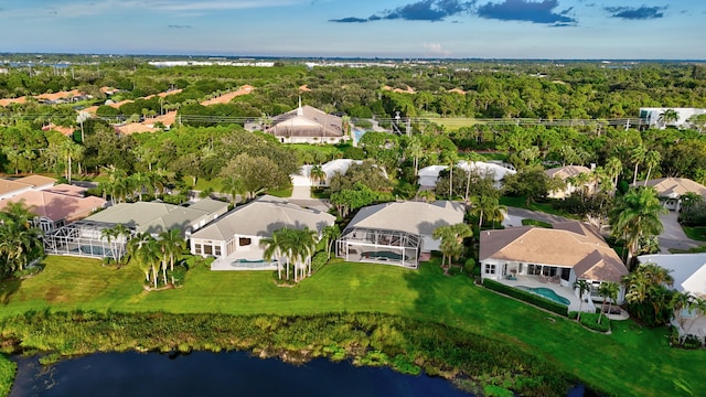 drone / aerial view featuring a view of trees, a residential view, and a water view