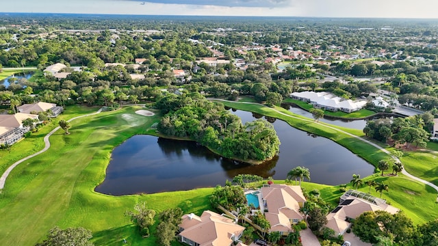 drone / aerial view featuring golf course view and a water view