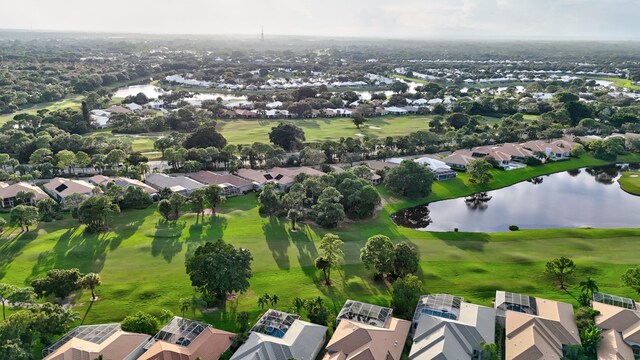 drone / aerial view with golf course view, a residential view, and a water view