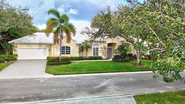 view of front of home with a front yard, concrete driveway, a garage, and stucco siding