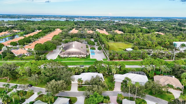 birds eye view of property with a wooded view and a water view