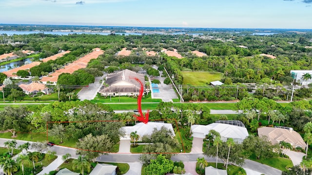 birds eye view of property with a wooded view and a water view