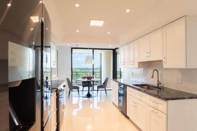 kitchen with stainless steel appliances, sink, tasteful backsplash, dark stone counters, and white cabinets