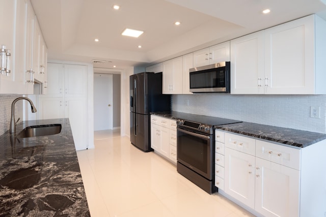 kitchen featuring decorative backsplash, appliances with stainless steel finishes, sink, and white cabinets