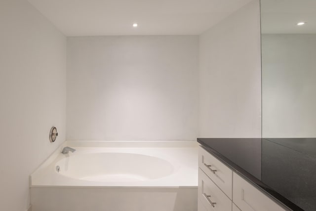 bathroom featuring a washtub and vanity