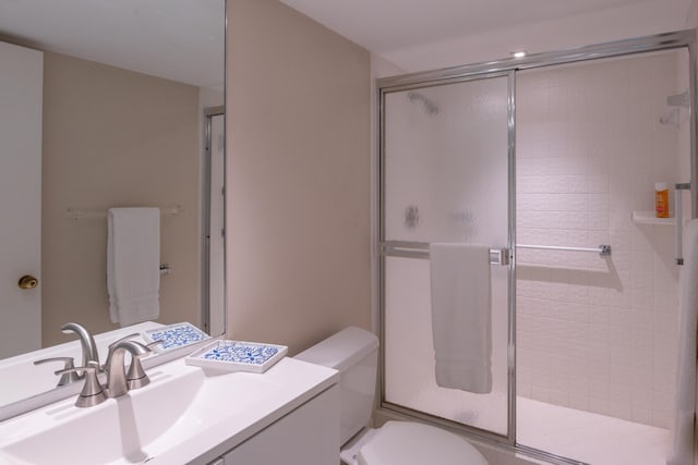 bathroom featuring walk in shower, vanity, and toilet