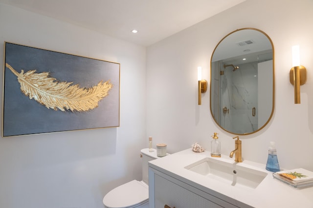 bathroom with a shower with door, vanity, and toilet