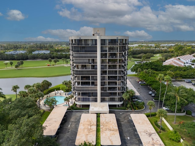 view of building exterior with a community pool and a water view