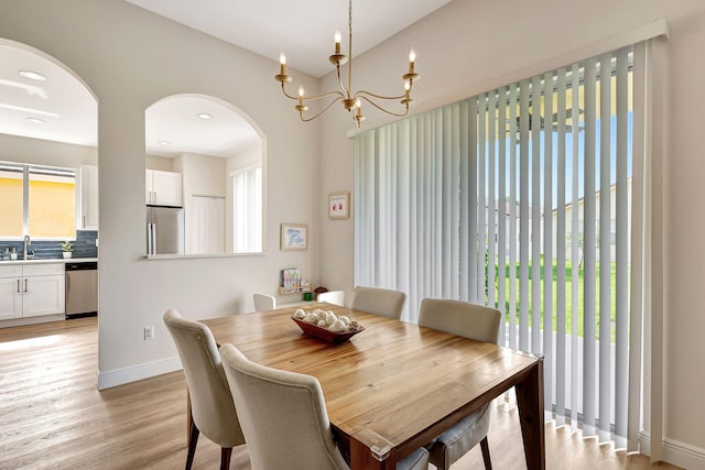 dining area featuring a chandelier, light wood-type flooring, and sink