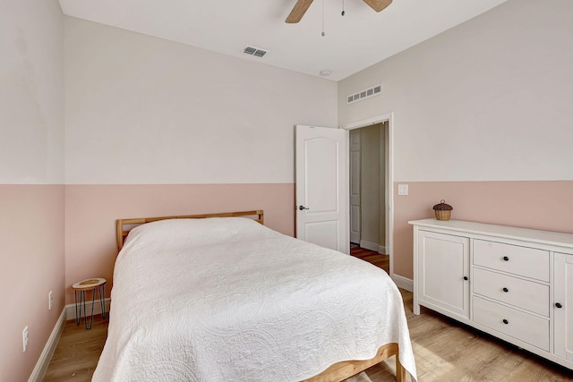 bedroom with light wood-type flooring, baseboard heating, and ceiling fan