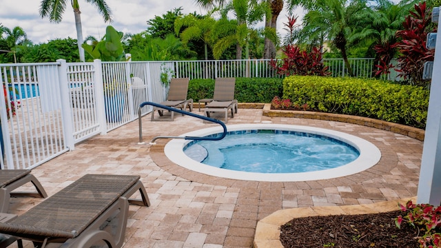 view of pool with an in ground hot tub and a patio