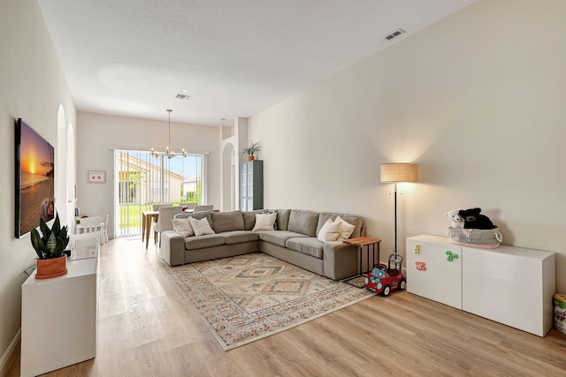 living room featuring light hardwood / wood-style floors and a chandelier