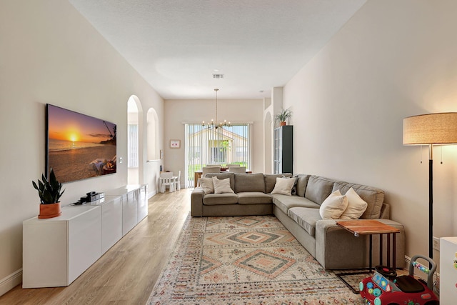 living room with a notable chandelier and light hardwood / wood-style floors