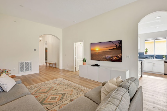 living room with sink and light hardwood / wood-style flooring