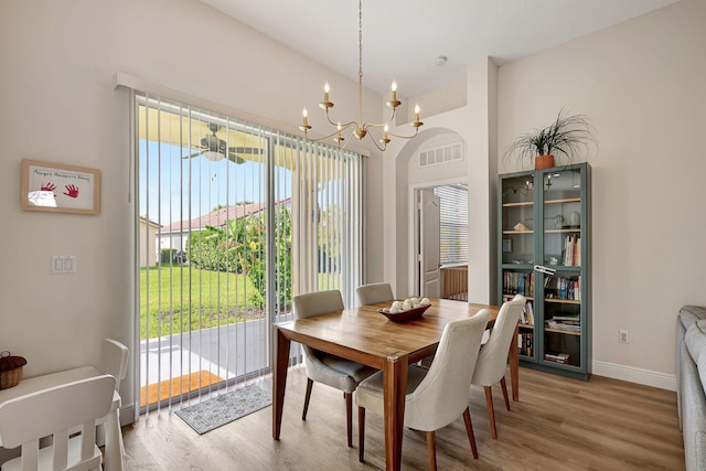 dining space with a wealth of natural light, hardwood / wood-style floors, and a chandelier