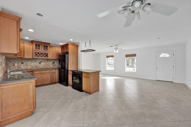 kitchen featuring light tile patterned floors, sink, black appliances, and kitchen peninsula