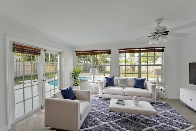 living room featuring ceiling fan, light tile patterned floors, and crown molding