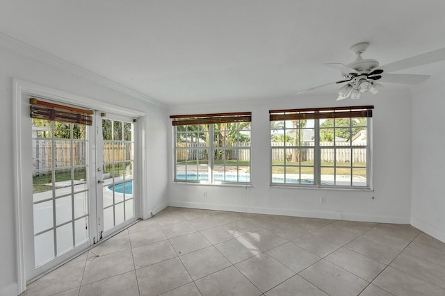 interior space featuring light tile patterned flooring, ceiling fan, a wealth of natural light, and ornamental molding