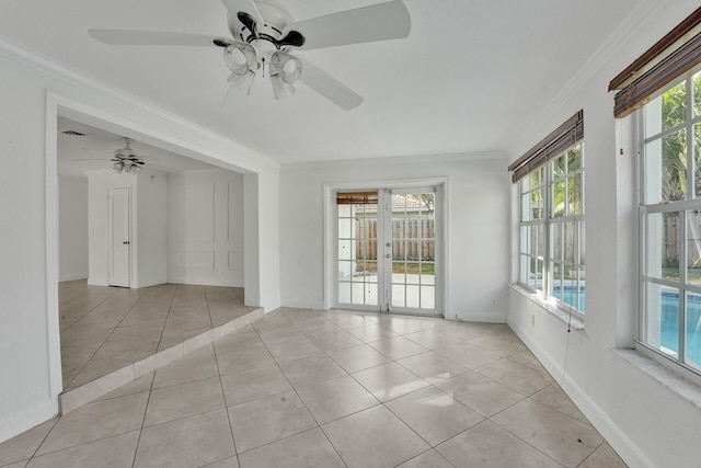 tiled spare room featuring a wealth of natural light, french doors, ceiling fan, and crown molding