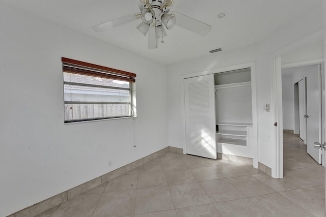 unfurnished bedroom featuring a closet, light tile patterned floors, and ceiling fan