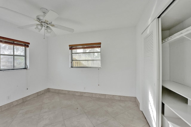 unfurnished bedroom featuring a closet, light tile patterned floors, and ceiling fan