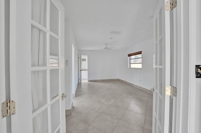 tiled empty room featuring ceiling fan