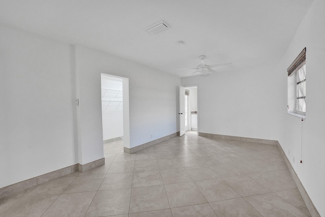 tiled empty room featuring ceiling fan