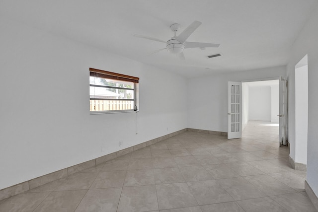 spare room with ceiling fan and light tile patterned flooring