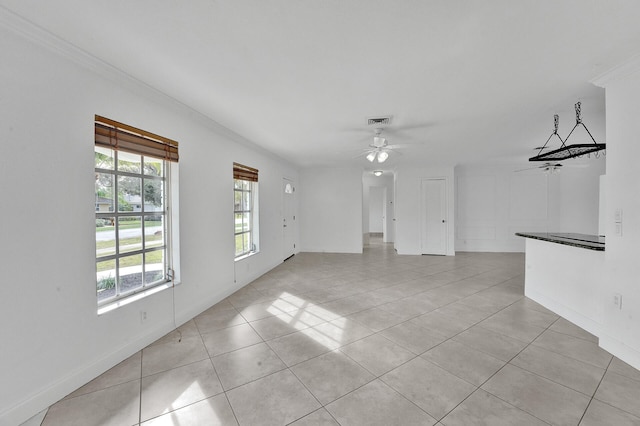 spare room featuring crown molding, light tile patterned flooring, and ceiling fan