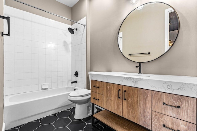 full bathroom featuring toilet, tiled shower / bath, tile patterned floors, and vanity