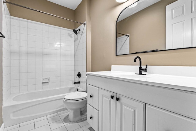 full bathroom featuring toilet, vanity, tiled shower / bath, and tile patterned flooring