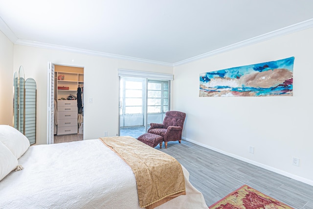 bedroom with crown molding, wood-type flooring, a closet, and a spacious closet