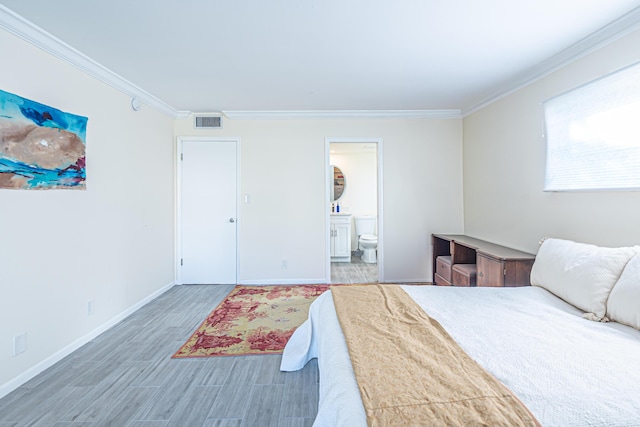 bedroom with connected bathroom, dark hardwood / wood-style floors, and crown molding