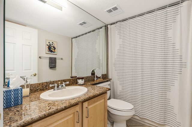 bathroom featuring tile patterned floors, toilet, a textured ceiling, vanity, and walk in shower