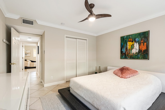 bedroom featuring light tile patterned floors, ceiling fan, crown molding, and a closet