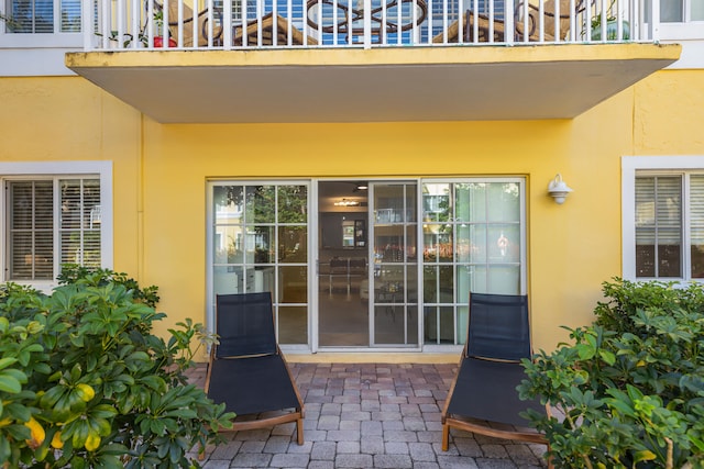 view of exterior entry with a balcony and a patio area