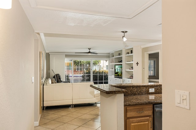 kitchen featuring crown molding, dark stone counters, light tile patterned floors, kitchen peninsula, and ceiling fan