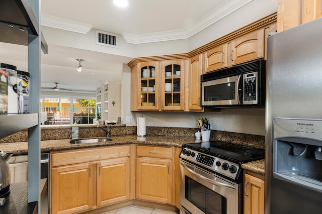 kitchen with ornamental molding, appliances with stainless steel finishes, sink, and dark stone countertops