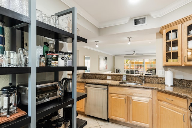 kitchen with sink, ornamental molding, dark stone countertops, light tile patterned floors, and stainless steel dishwasher