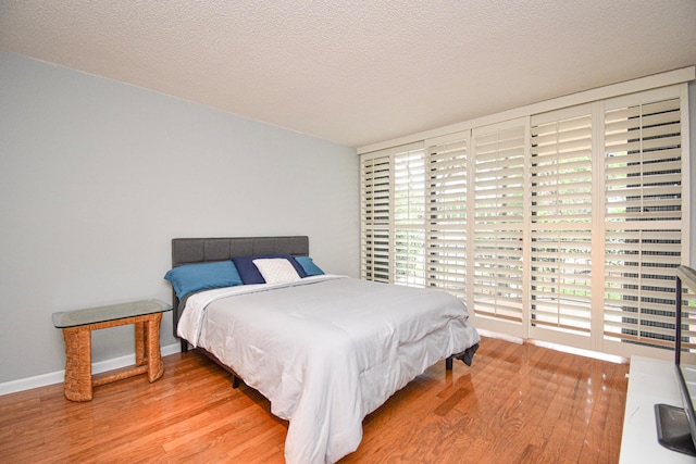 bedroom with wood-type flooring and a textured ceiling