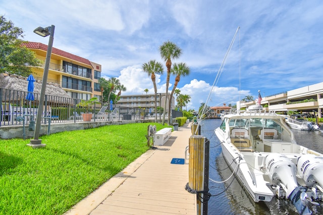 view of dock with a yard and a water view