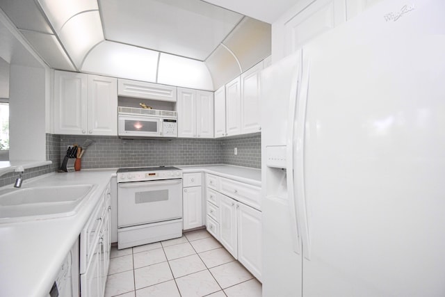 kitchen with white cabinets, white appliances, light tile patterned floors, and sink