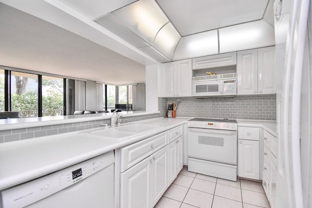 kitchen featuring white cabinetry, sink, tasteful backsplash, light tile patterned floors, and white appliances